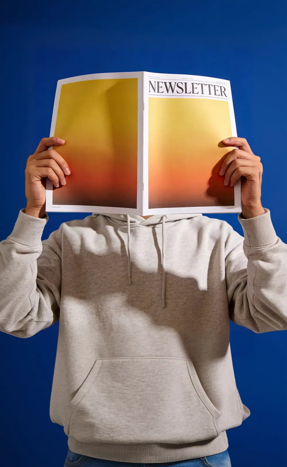 Someone reading a newsletter held up in front of their face