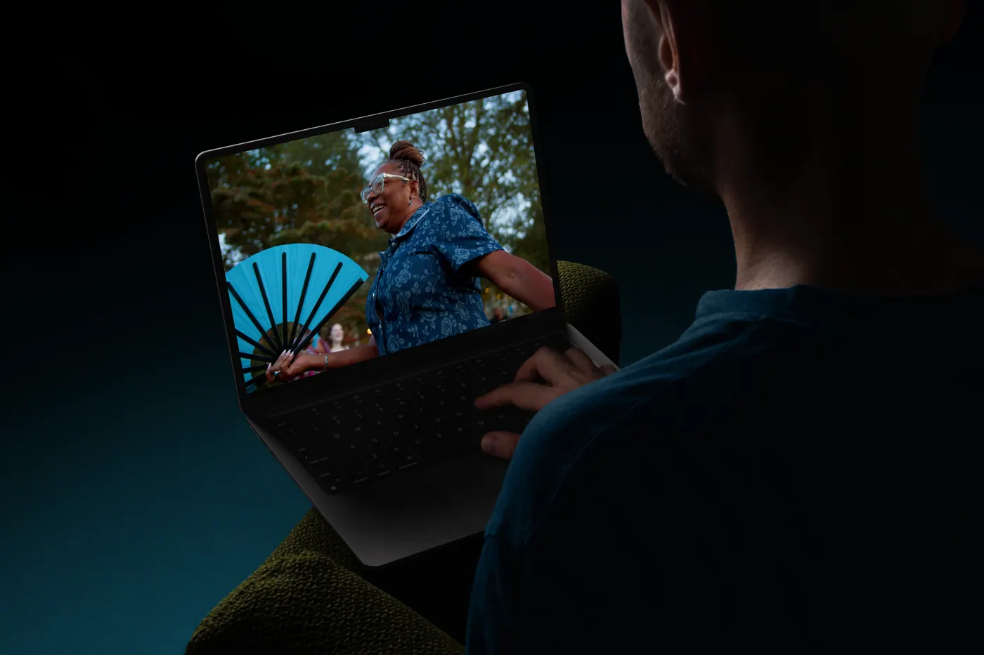 A person watching a video on a laptop in a dark room
