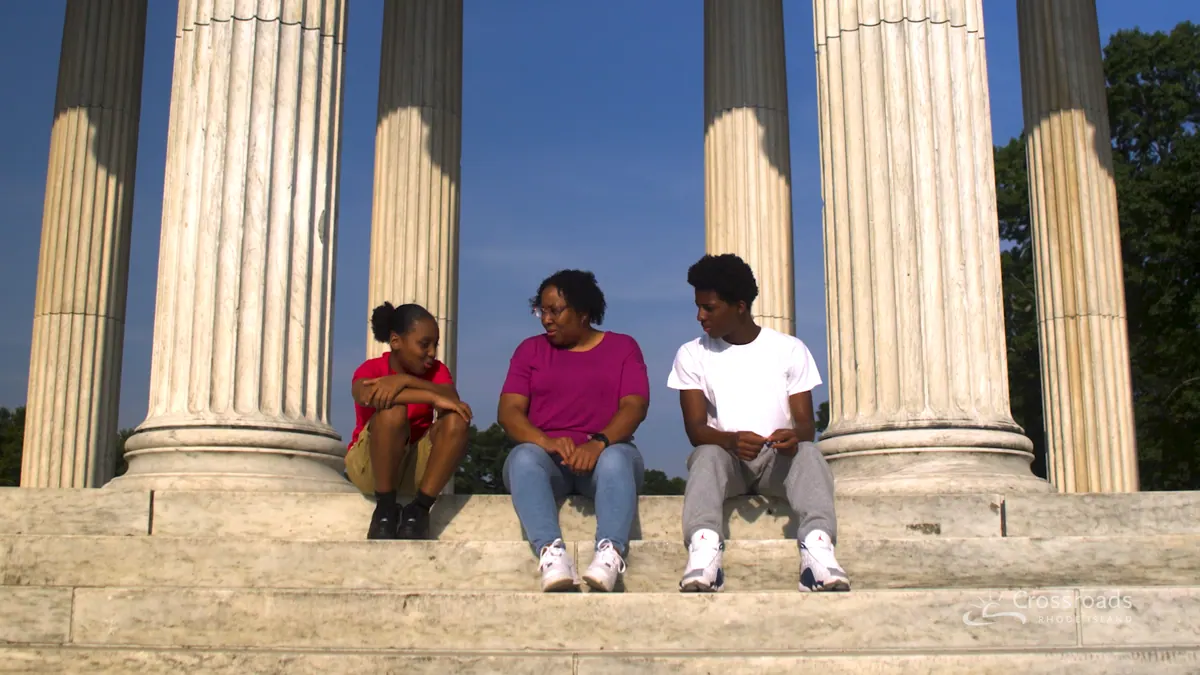 Three friends sitting on the steps of a columned monument