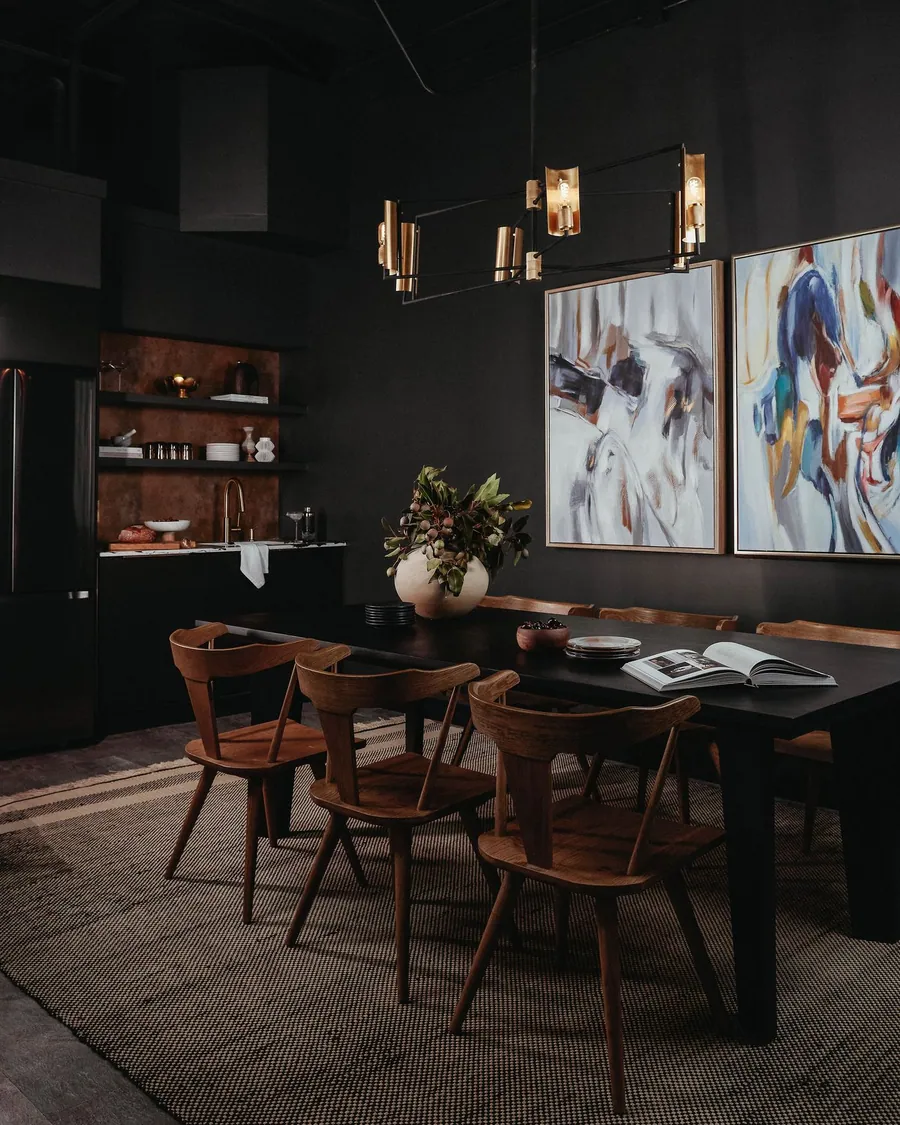 Suite 101: a dining table under pendant lights and large abstract paintings