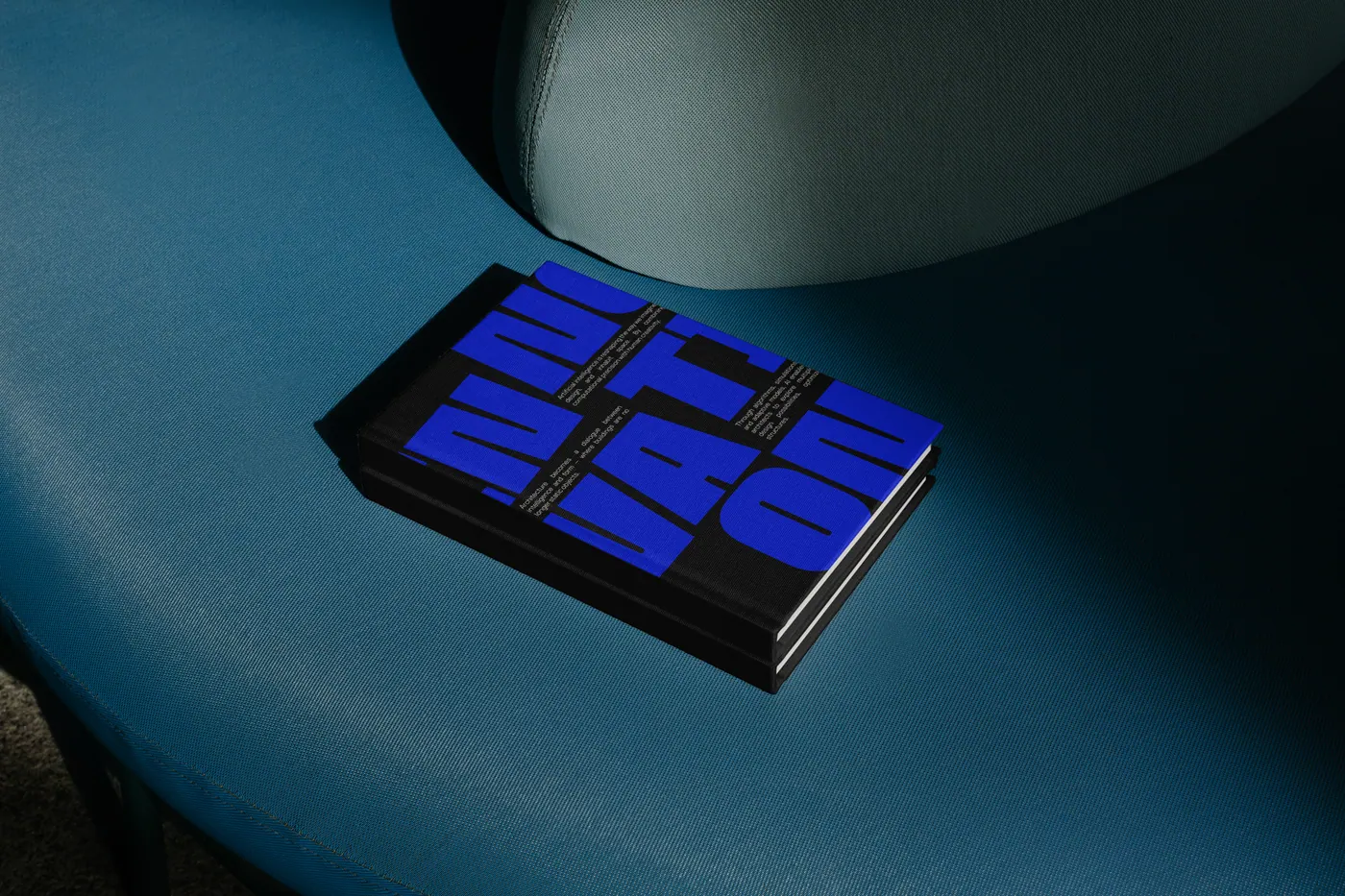 A stack of blue Arche-tech books on a teal chair