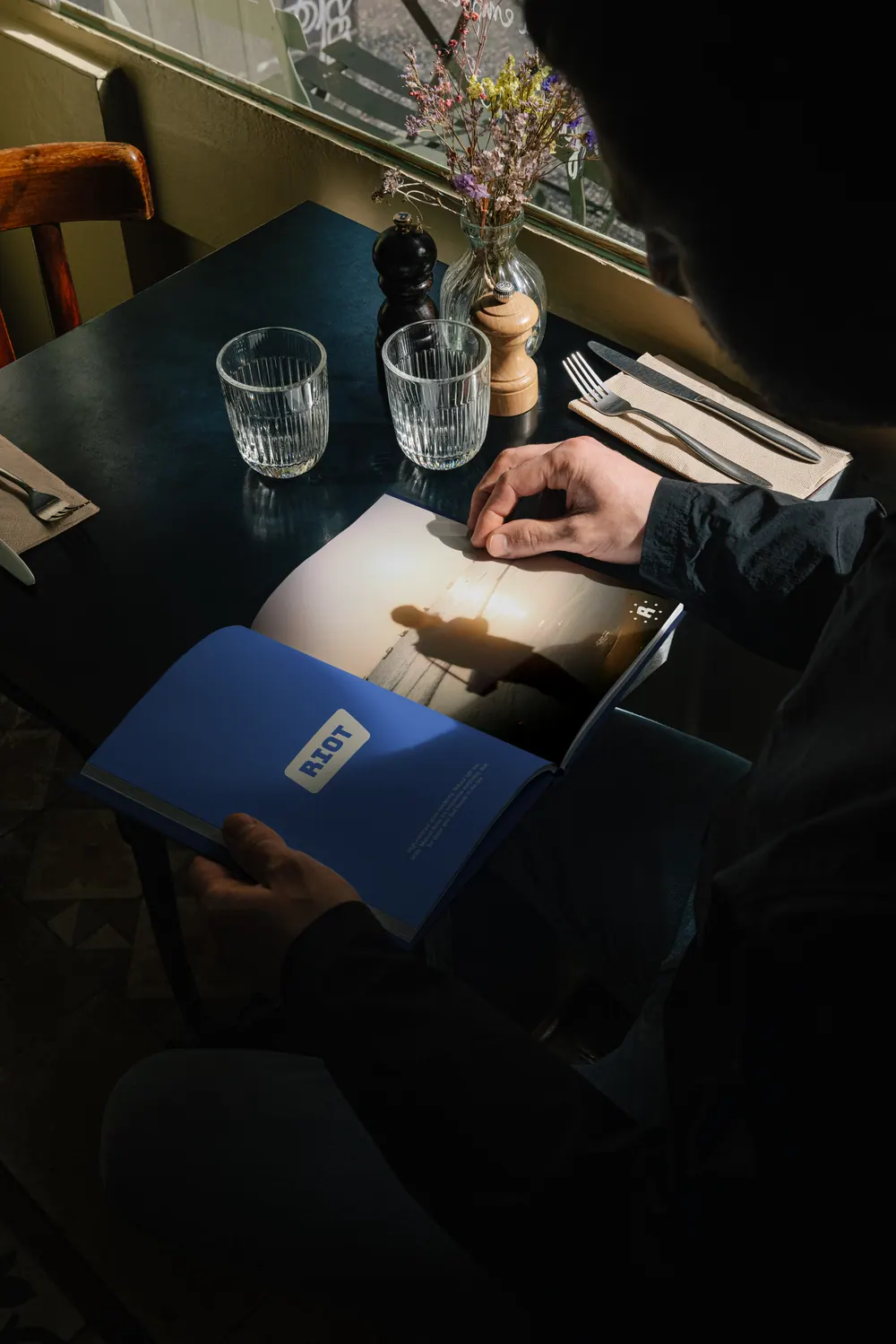 A RIOT! Cameras booklet on a dark table